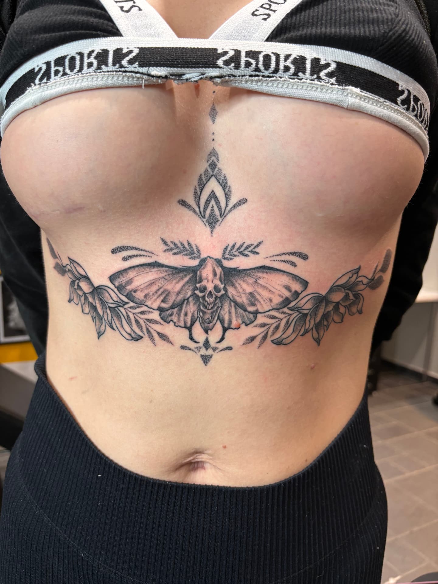 Dotwork dödskalle och nattfjäril på bröstbenet